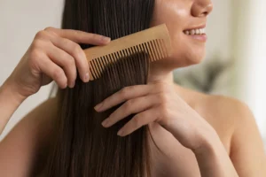 Kobieta czesze włosy drewnianym grzebieniem